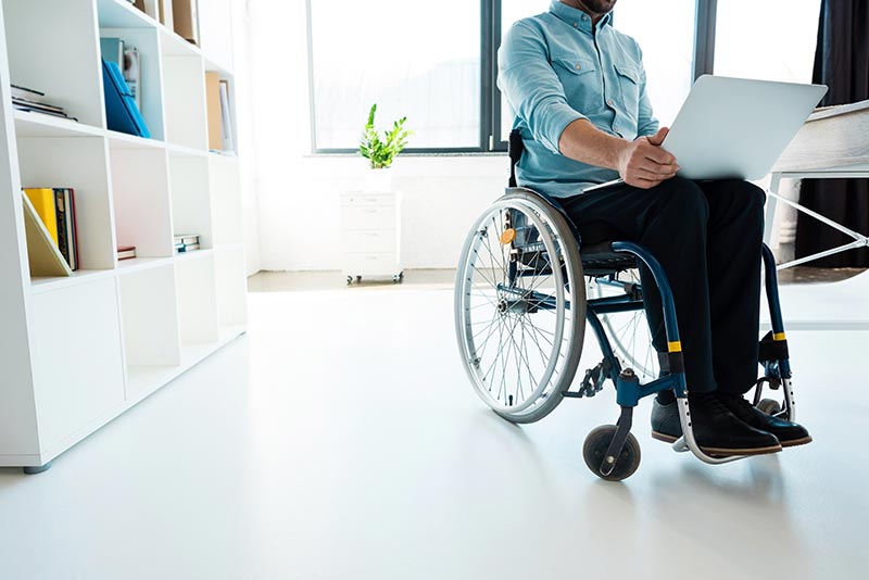 Barrierefreier Arbeitsplatz: Rollstuhlfahrer am Arbeiten