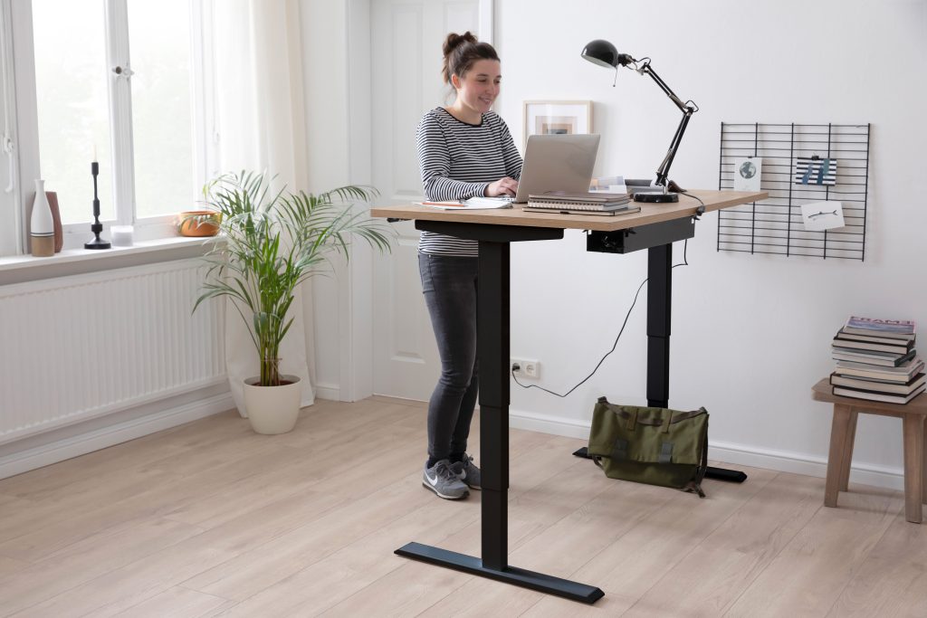 Nahaufnahme eines höhenverstellbaren Stehtisches, angepasst an die optimale Arbeitshöhe für komfortables und ergonomisches Arbeiten im Stehen.