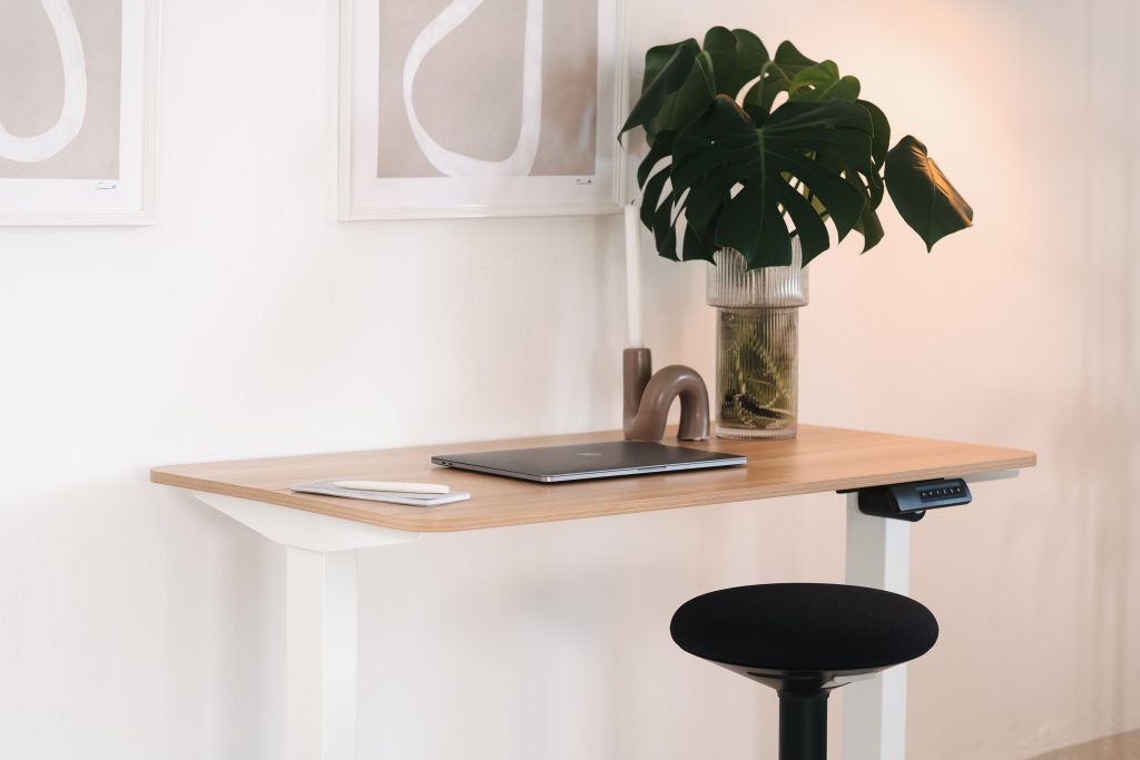 Minimalistisches ergonomisches Bürosetup mit höhenverstellbarem Schreibtisch und Stehhilfe Büro für flexibles Arbeiten im modernen Arbeitsumfeld.